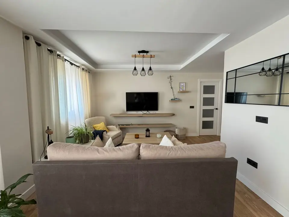 Salón reformado en Valladolid con techo rebajado, iluminación y suelo laminado